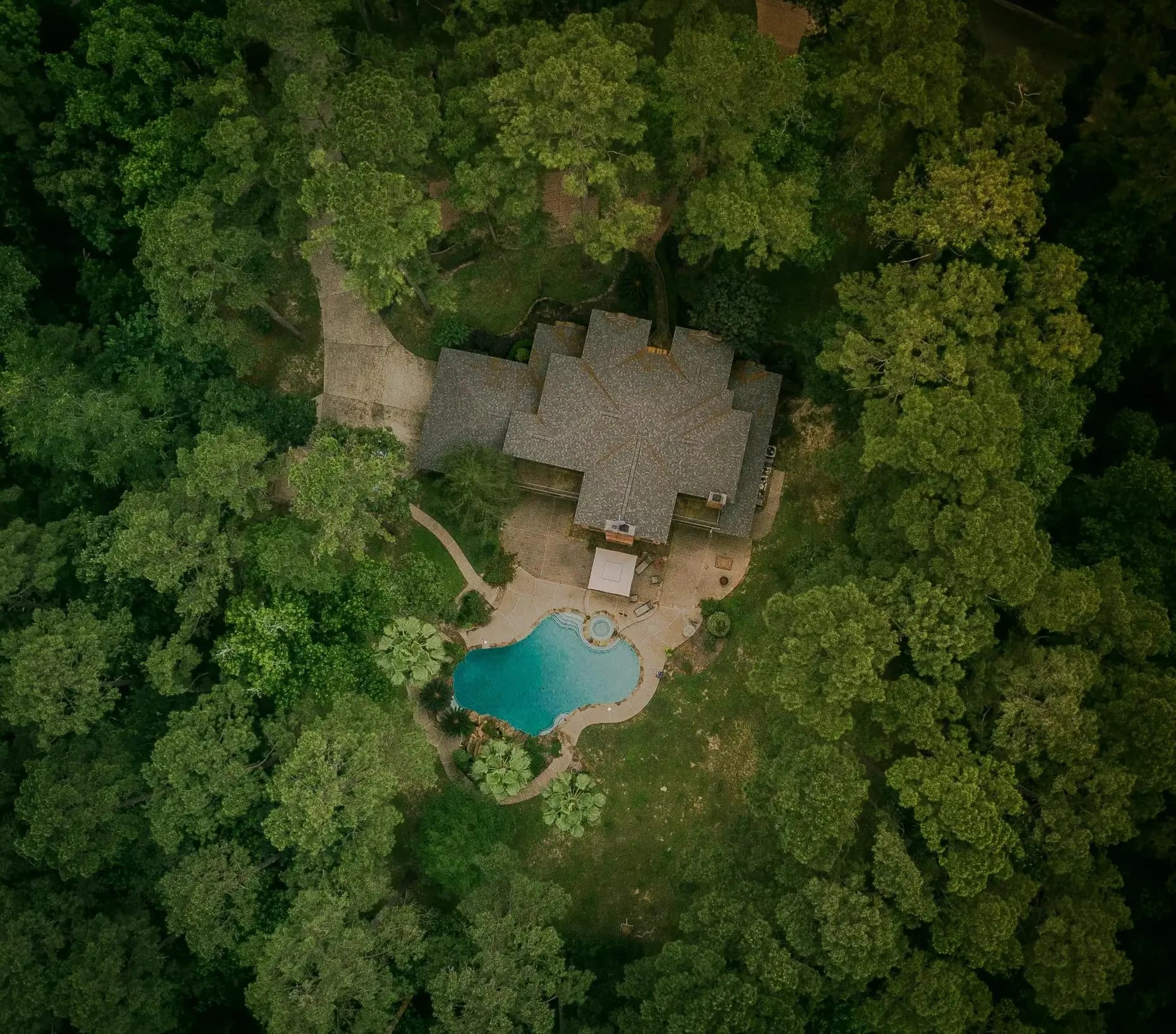 Aerial view of Atlanta luxury estate with swimming pool surrounded by mature trees