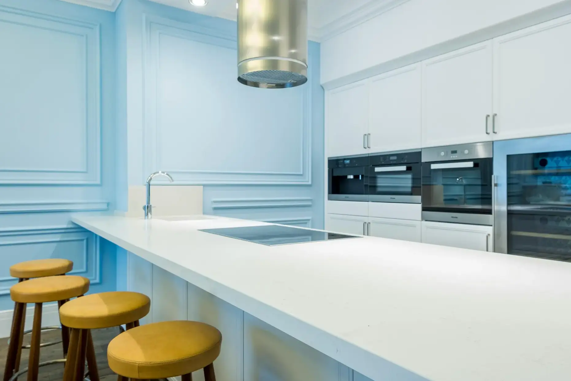 Gourmet kitchen with blue wainscoting, white quartz island and professional appliances